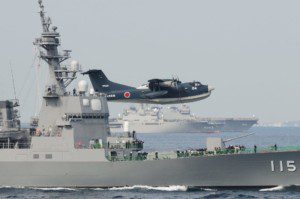 Un idrovolante Shinmaywa US-2I sorvola un caccia classe Kongo. Alcuni esemplari dell'aereo potrebbero essere acquistati dall'India in seno agli ultimi accordi bilaterali.